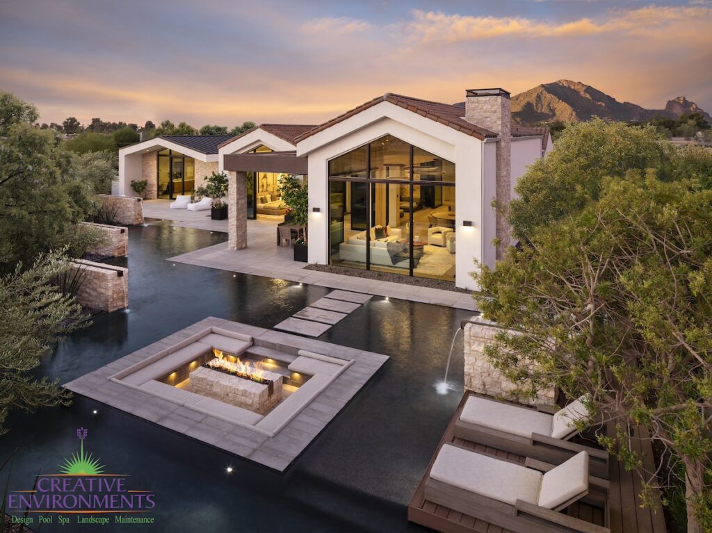 Custom backyard design with sunken fire pit, Jesus steps and metal scupper water feature.